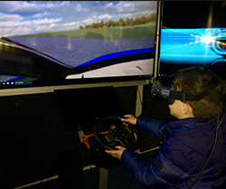 boy wearing virtual reality goggles drives a simulator