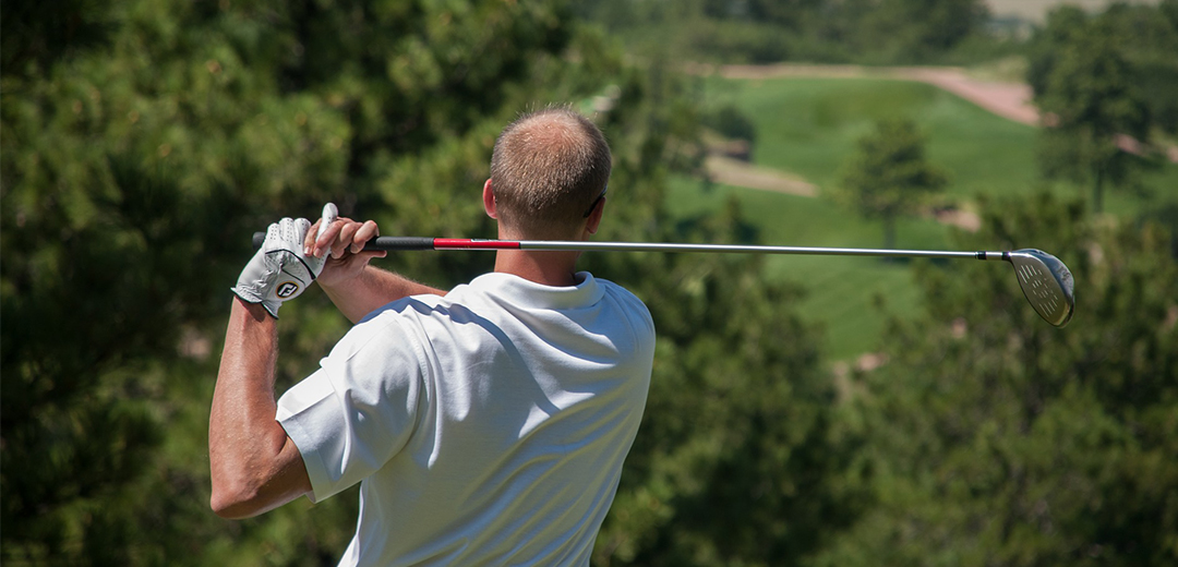 man swinging a golf club in the air