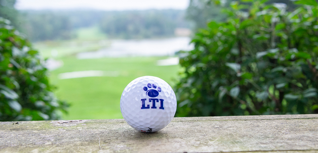 LTI branded golf ball with blurred background of golf course