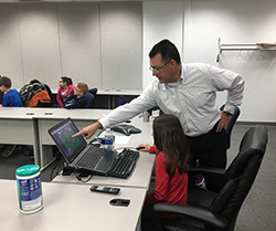 Eric Donnell explaining a computer game to a young female student