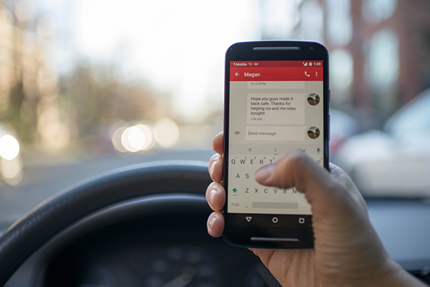 smart phone being used in front of a steering wheel